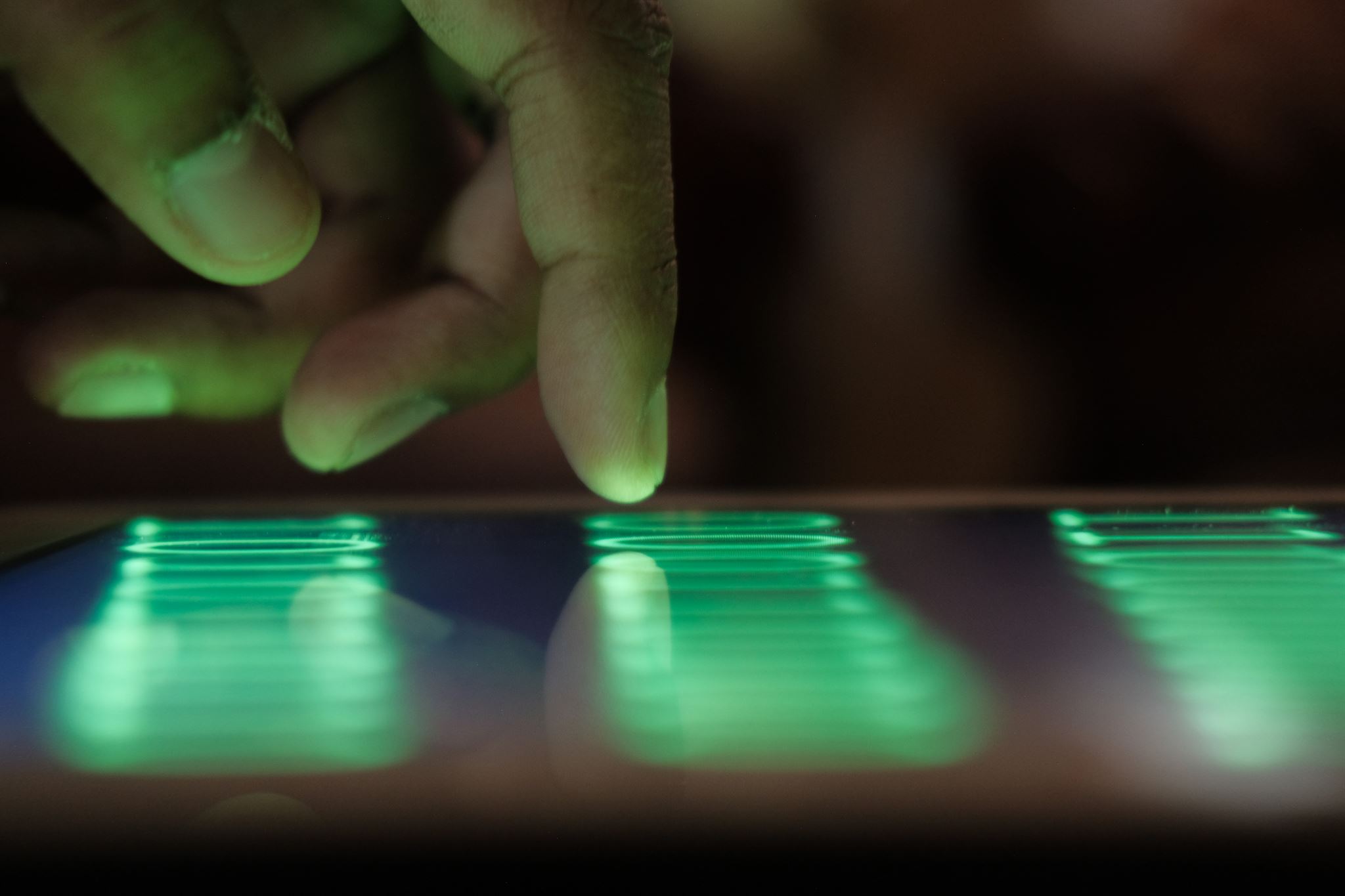 A-finger-pointing-on-a-tablet-with-green-neon-lights